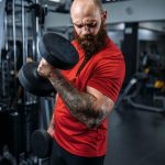 athlete-doing-exercise-with-dumbbells-in-gym-RHNJB3M.jpg